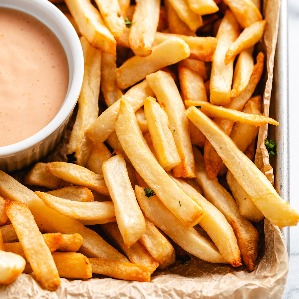 French fries on a tray with parchment paper.