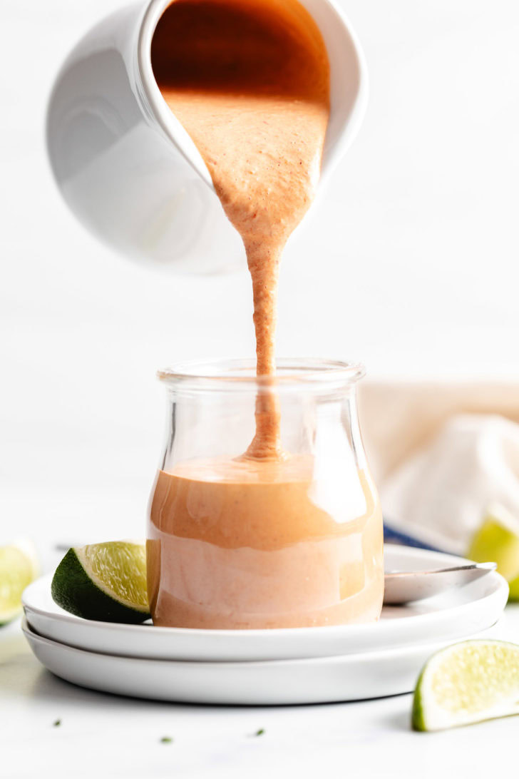 Chipotle Sauce White jar pouring chipotle sauce into a jar.