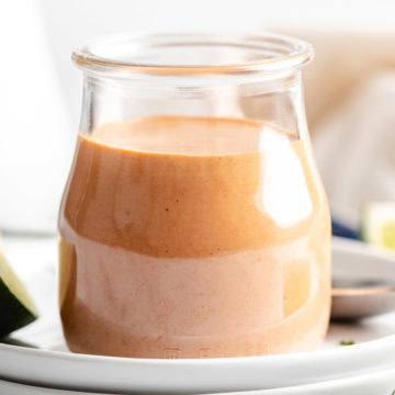 Side view of a jar filled with spicy cream sauce.