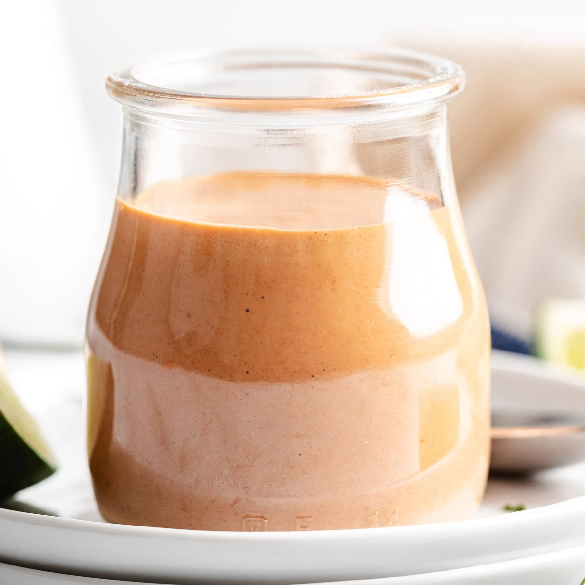 Side view of a jar filled with spicy cream sauce.