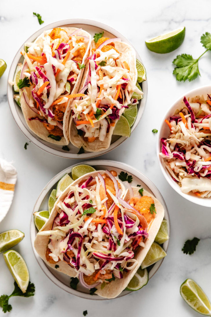 Overhead view of two plates of fish stick tacos.