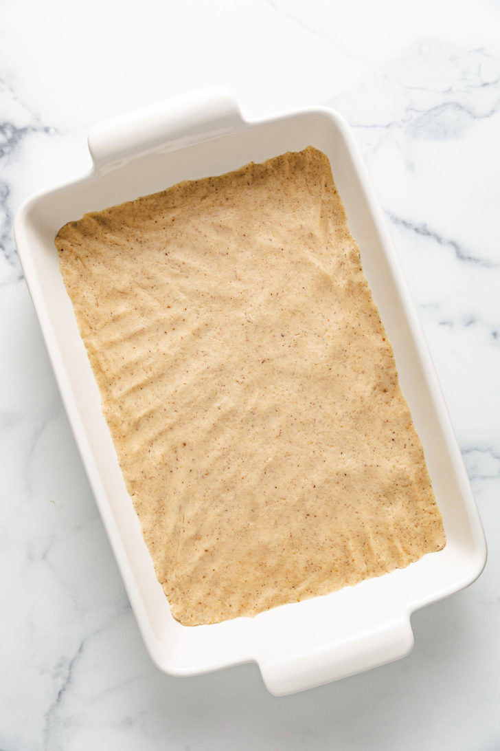 Dough pressed into a baking dish.