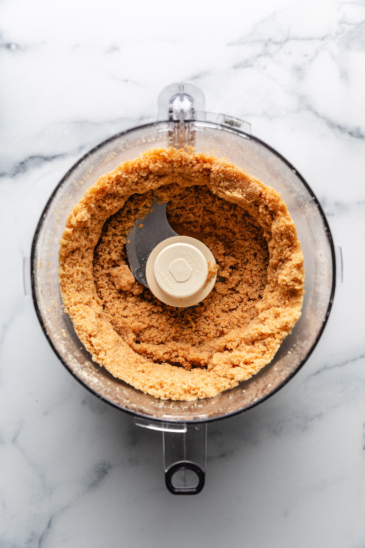 Cookies, sugar, and butter mixed in a food processor.
