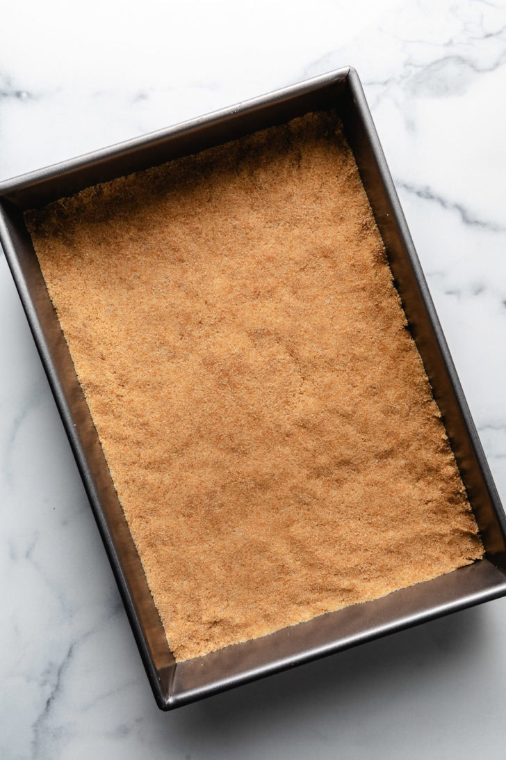 Crushed vanilla wafer pressed into a pan.