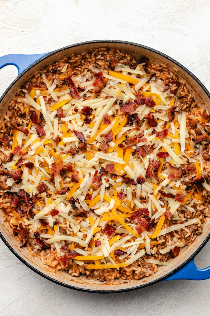 Shredded cheese added to cheeseburger rice skillet.