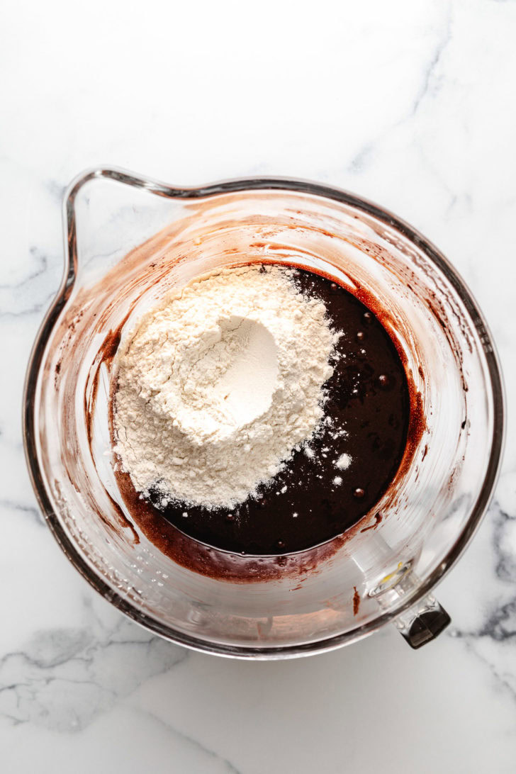 Flour on top of cocoa mixture in a bowl.