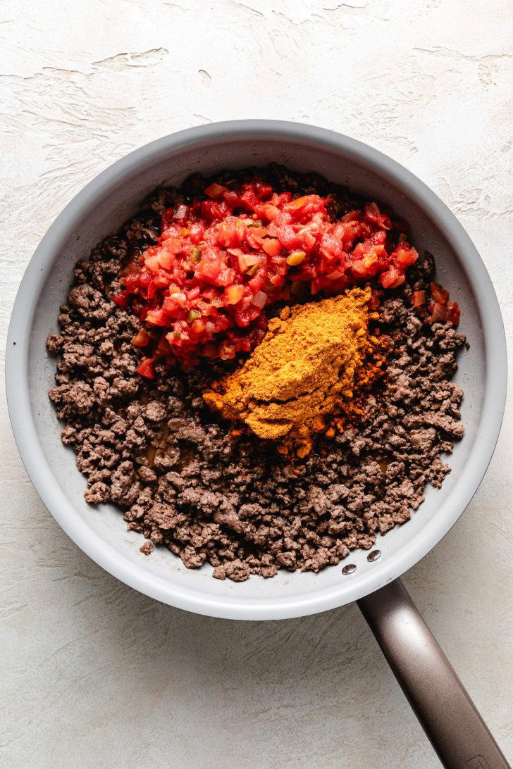 Ground beef, salsa, and seasoning in a pan.