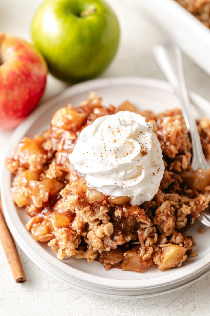 Whipped cream on top of apple crisp.