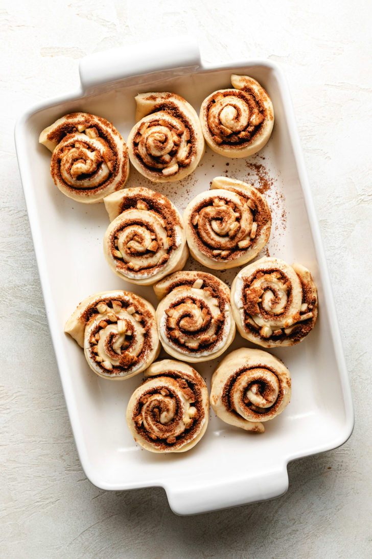Unbaked cinnamon rolls in a pan.