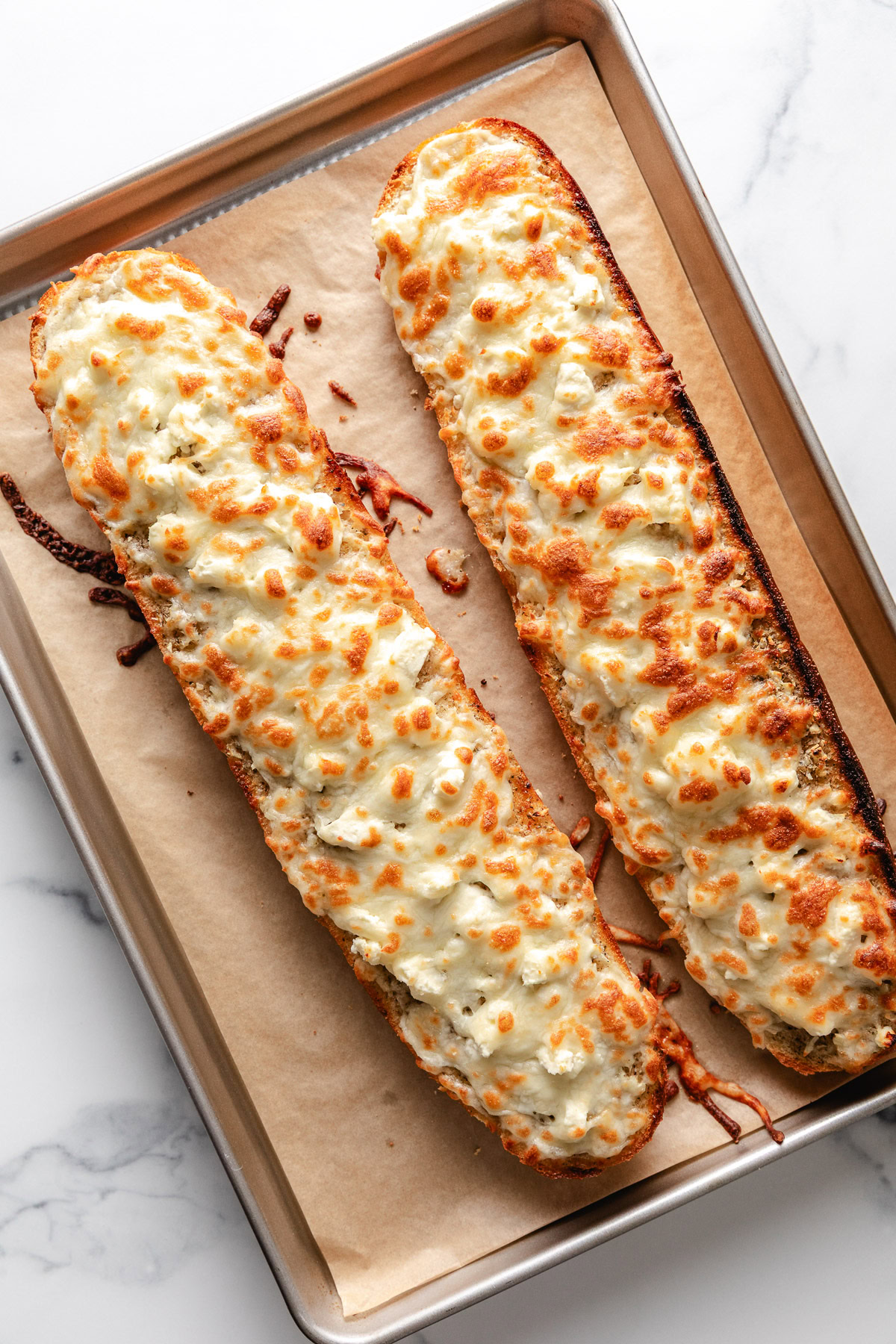 Overhead view of two half loaves of garlic bread.