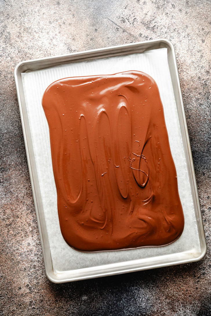 Melted chocolate almond bark spread over waxed paper.