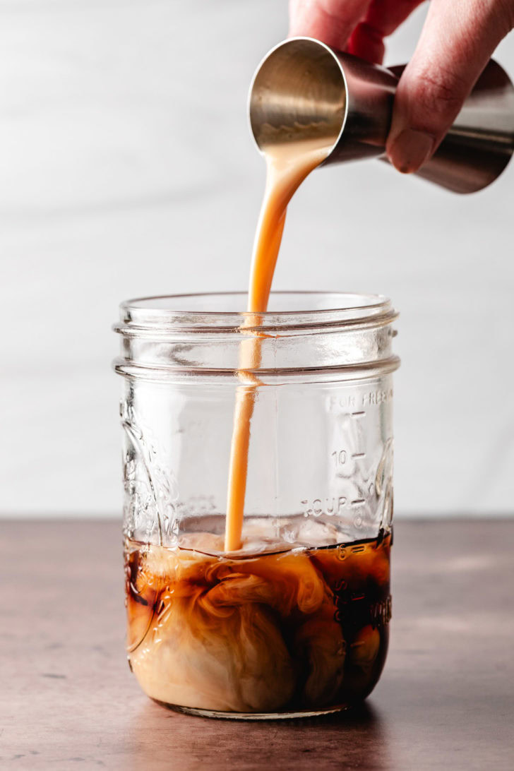 Pumpkin liqueur being poured into a jar.