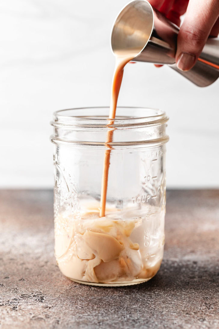 Irish cream being poured into a jar.