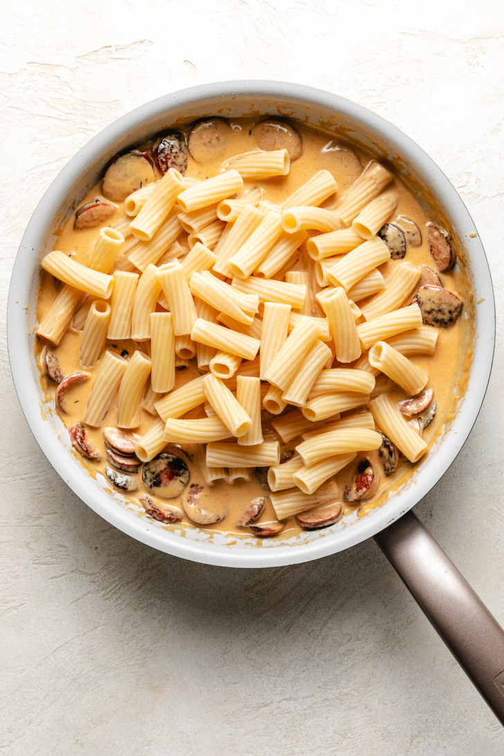 Noodles on top of cajun alfredo and sausage.