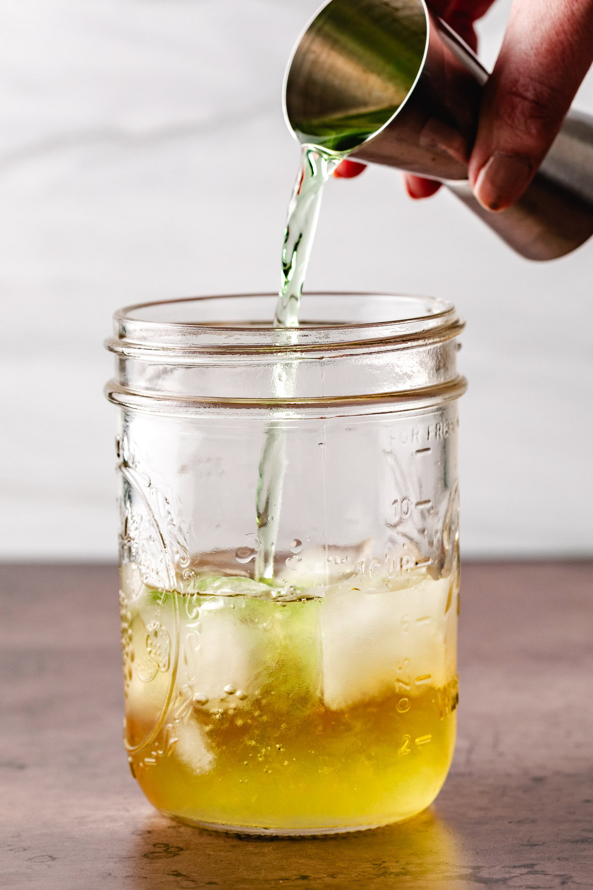 Sour apple pucker being poured into a jar.