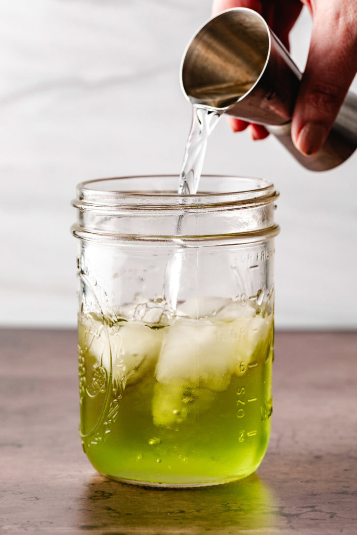 4&Ndash;Ingredient Sour Apple Martini Triple sec being poured into a jar.