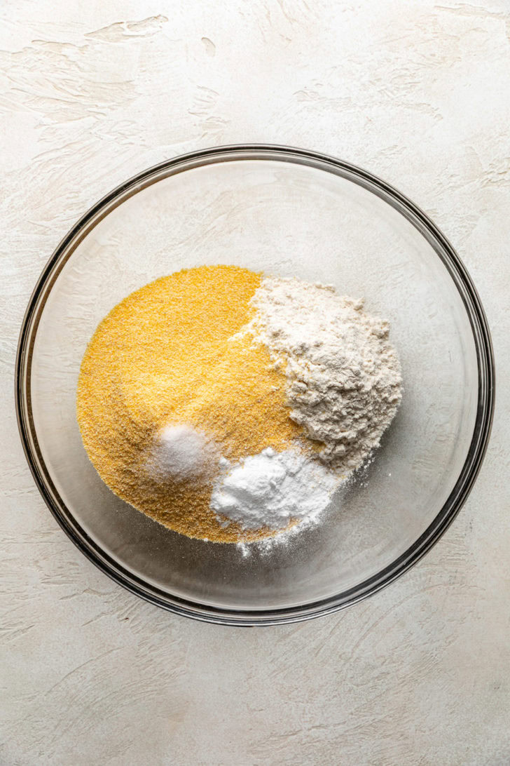 Moist Cornbread Muffins Cornmeal, flour, baking powder, and salt in a bowl.