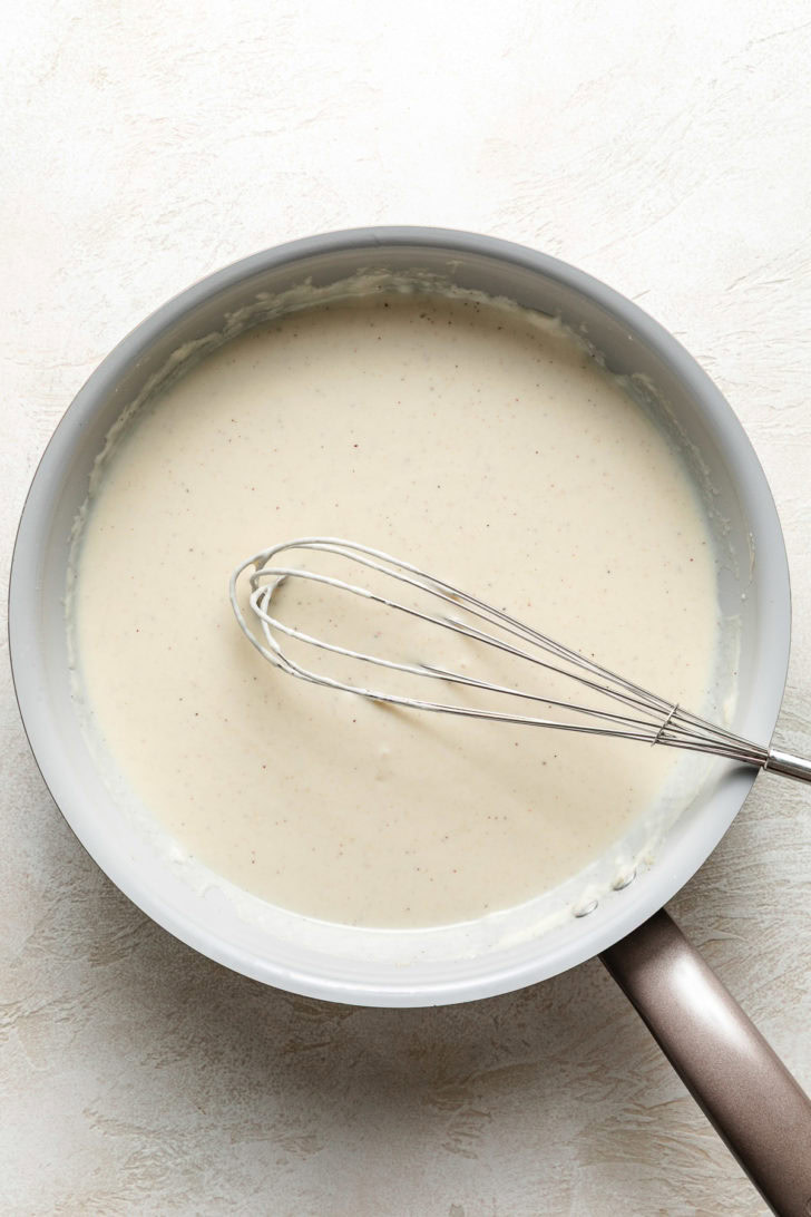 Milk and heavy in a pan with a whisk.