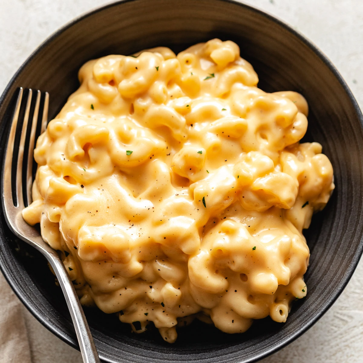 Close up view of blue bowl filled with mac and cheese.
