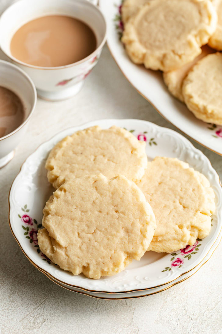 Plate of cookies with tea cups.