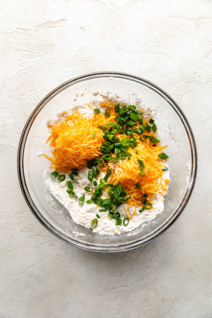 Easy Cheddar Scallion Biscuits Ingredients for biscuits in a glass bowl.