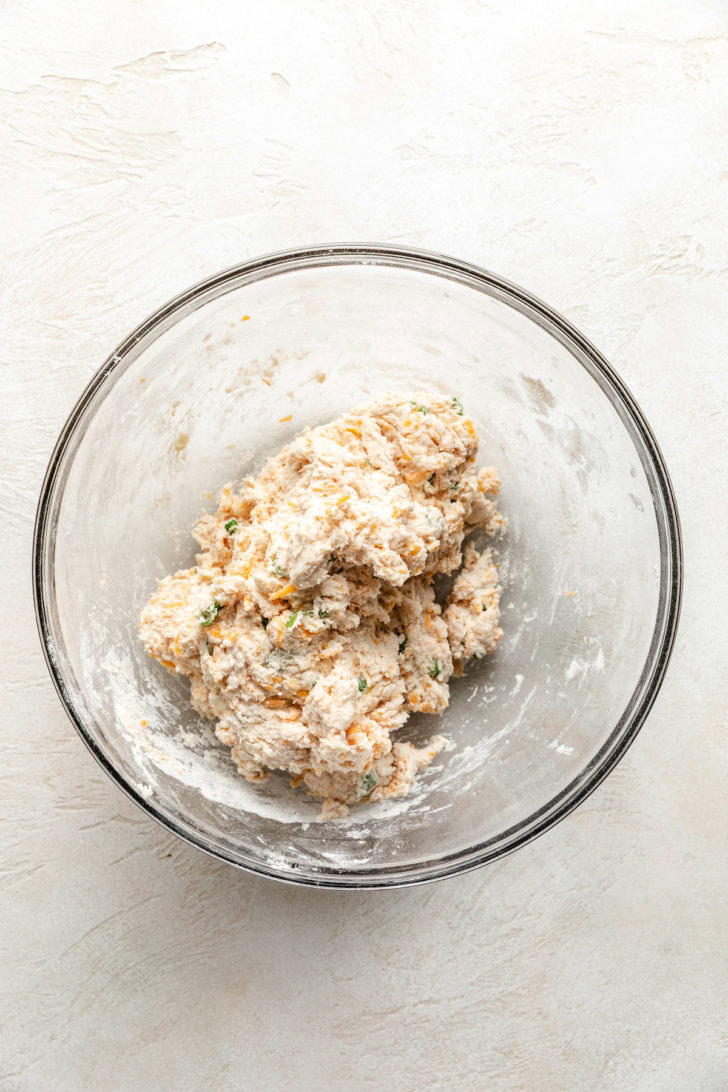 Easy Cheddar Scallion Biscuits Biscuit dough in a glass bowl.