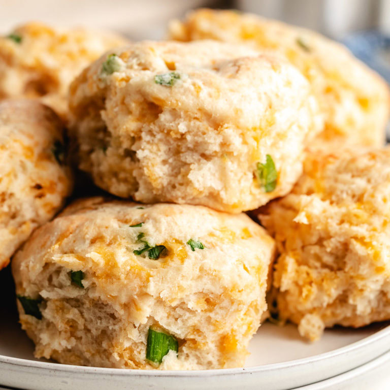 Close up view of cheddar scallion biscuits on a plate.