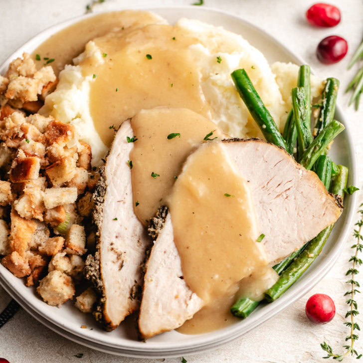 Close up view of crockpot garlic herb turkey breast with gravy.