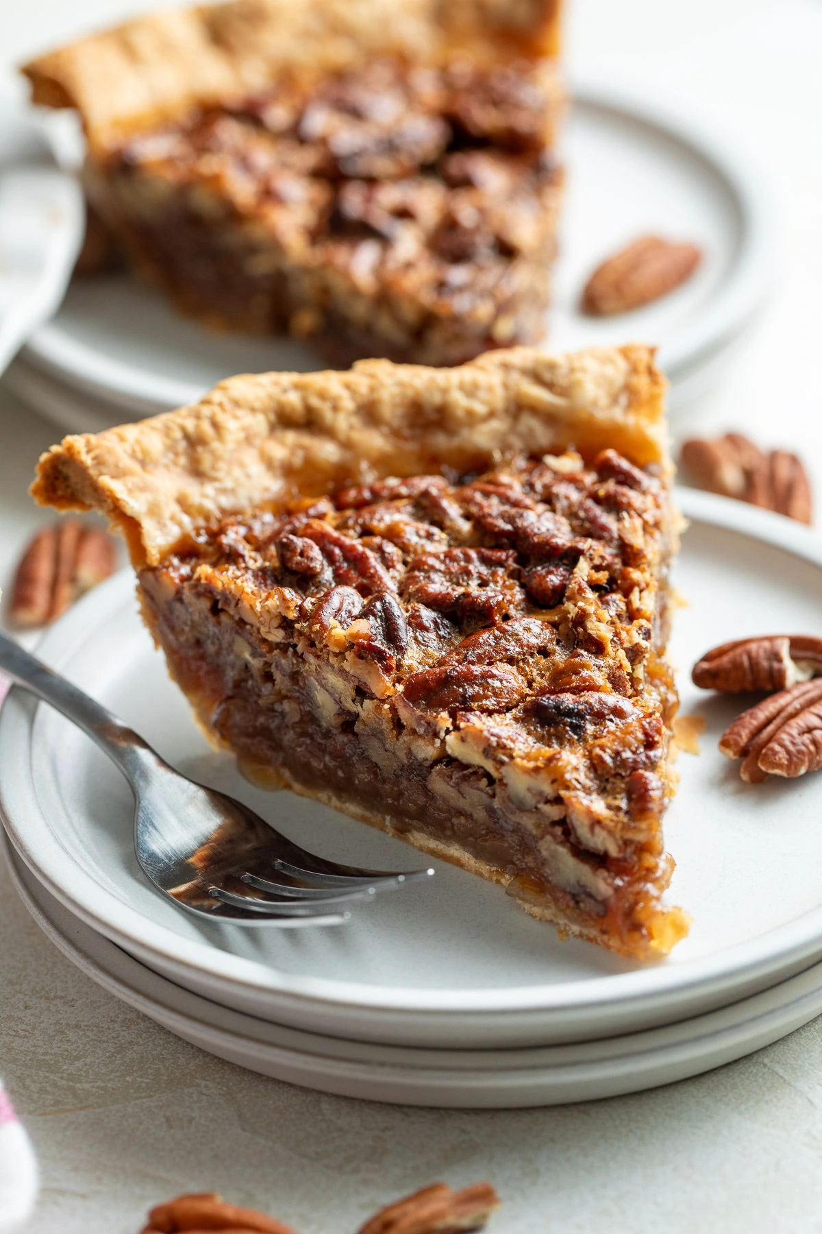 Pecan pie on a stack of plates.
