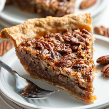 Fork next to a slice of pecan pie.