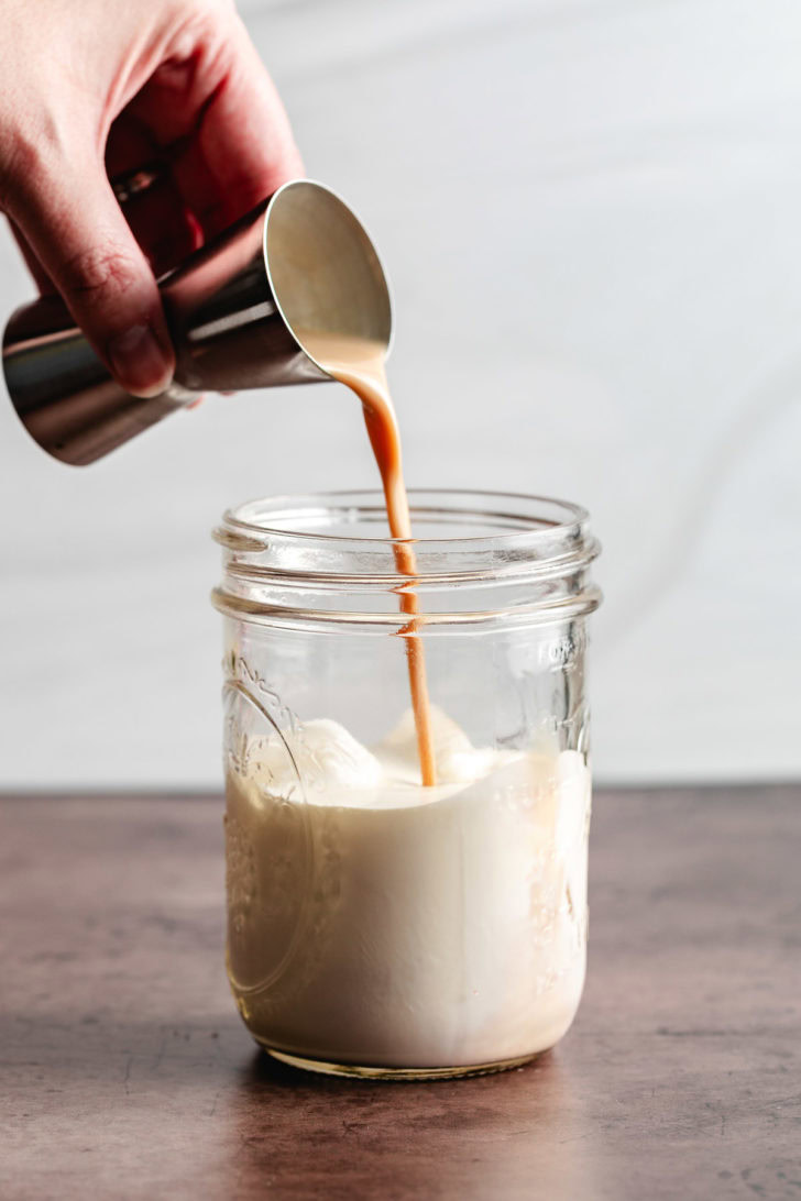 Bailey's irish cream being poured into a mason jar.