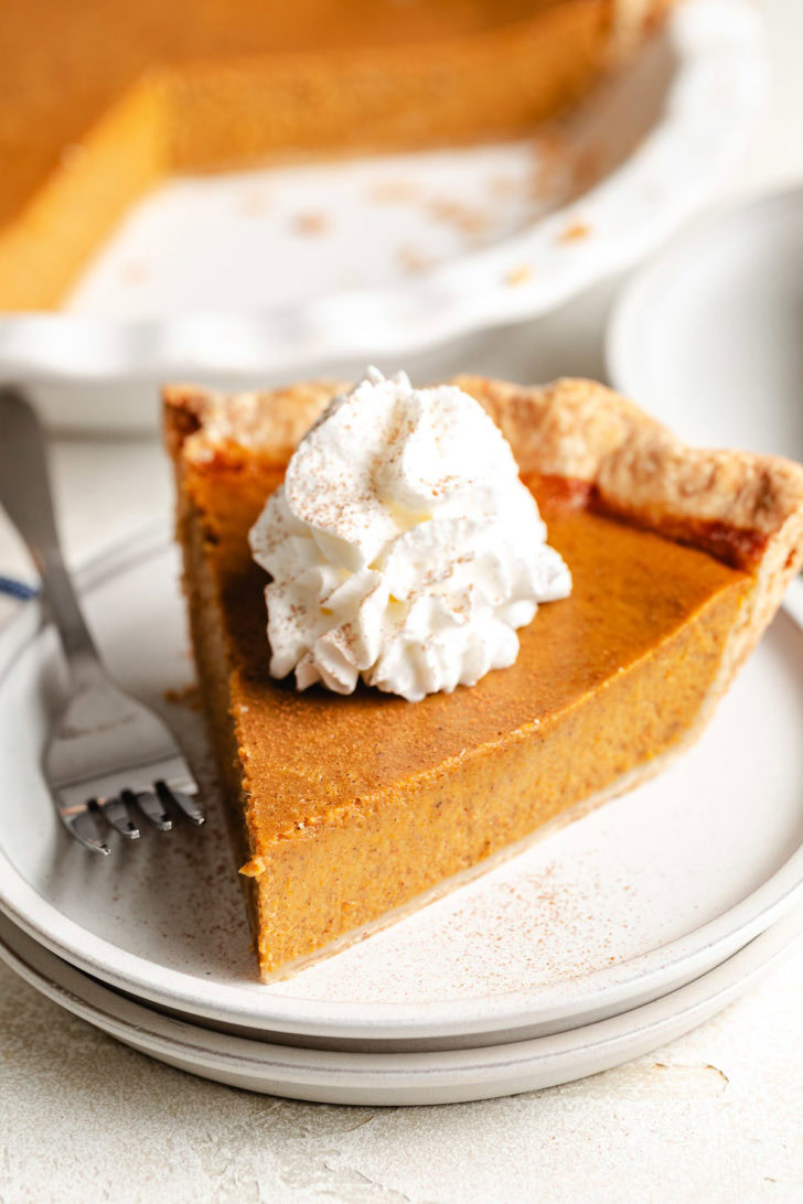 Perfect Pumpkin Pie Whipped cream on a slice of pie.