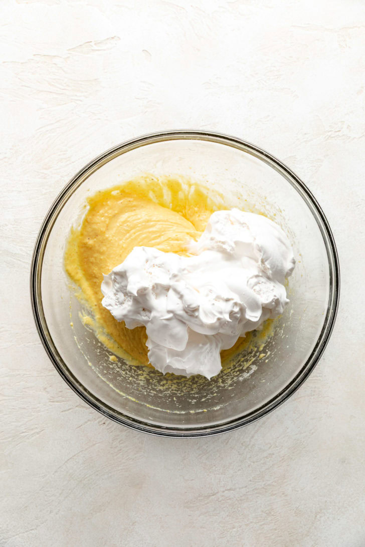 Mixing eggnog and whipped cream.