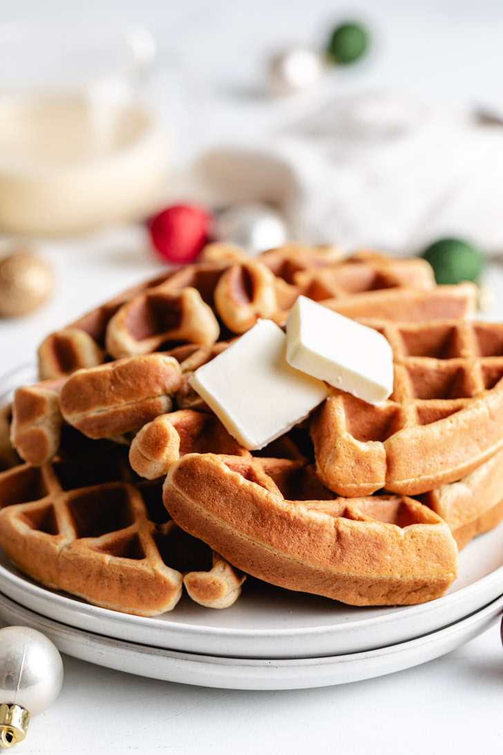 Easiest Eggnog Waffles Stack of eggnog waffles with butter.