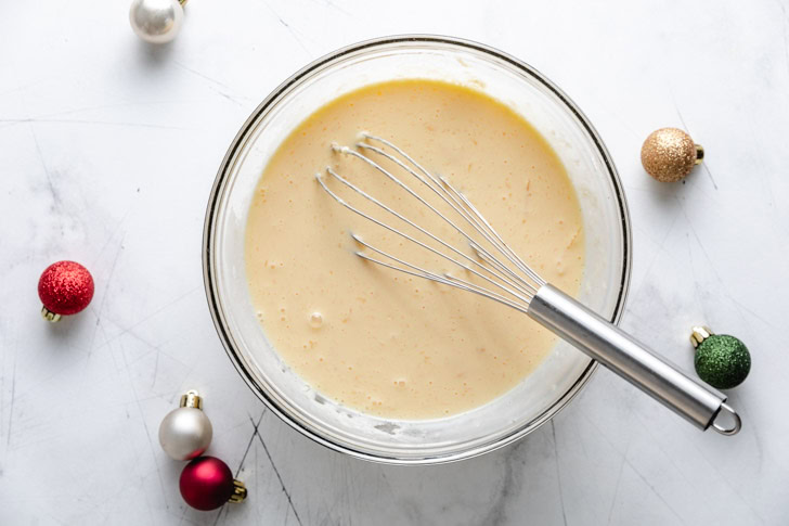 Easiest Eggnog Waffles Bowl of eggnog batter with decorations.