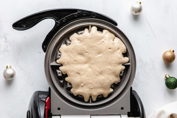Easiest Eggnog Waffles Waffle batter in a waffle maker.