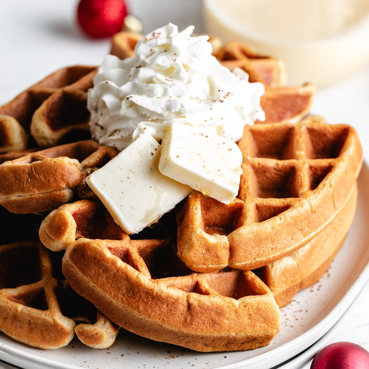 Eggnog waffles topped with whipped cream and butter.
