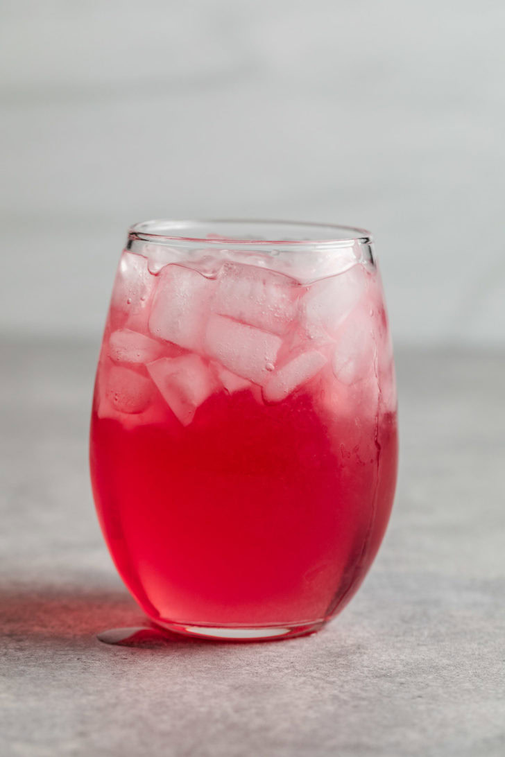 Festive Vodka Cranberry Cocktail Bright pink drink with ice.