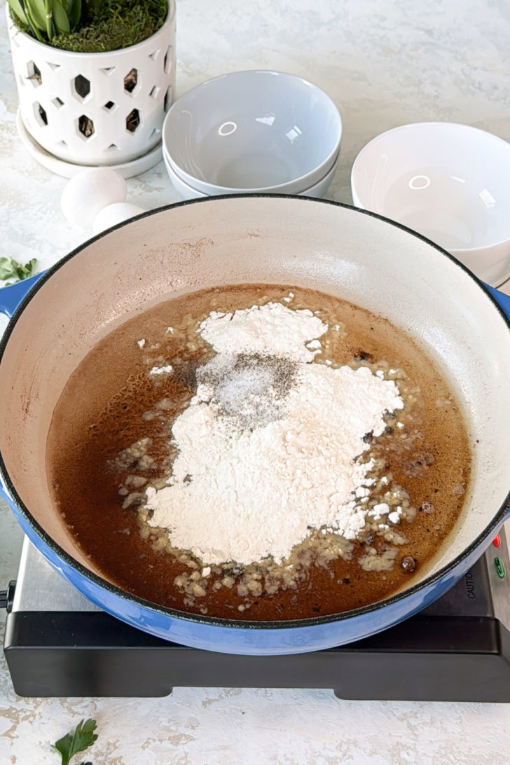 Flour and black pepper added to skillet drippings to start the gravy for chicken fried steak.