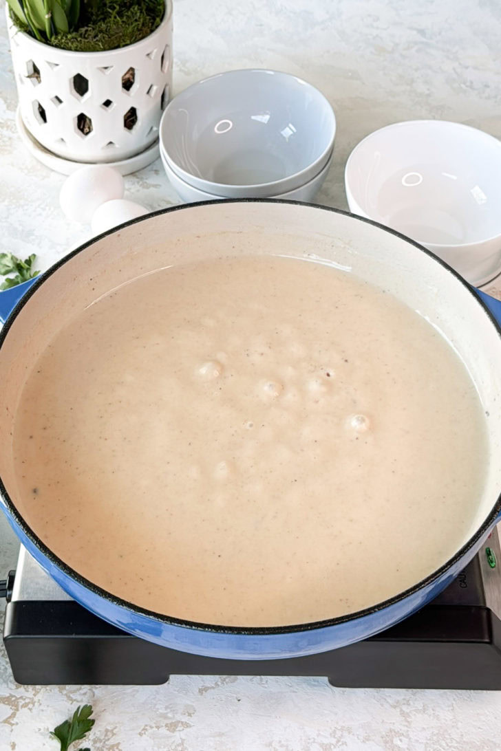 Creamy pepper gravy cooking in a wide skillet