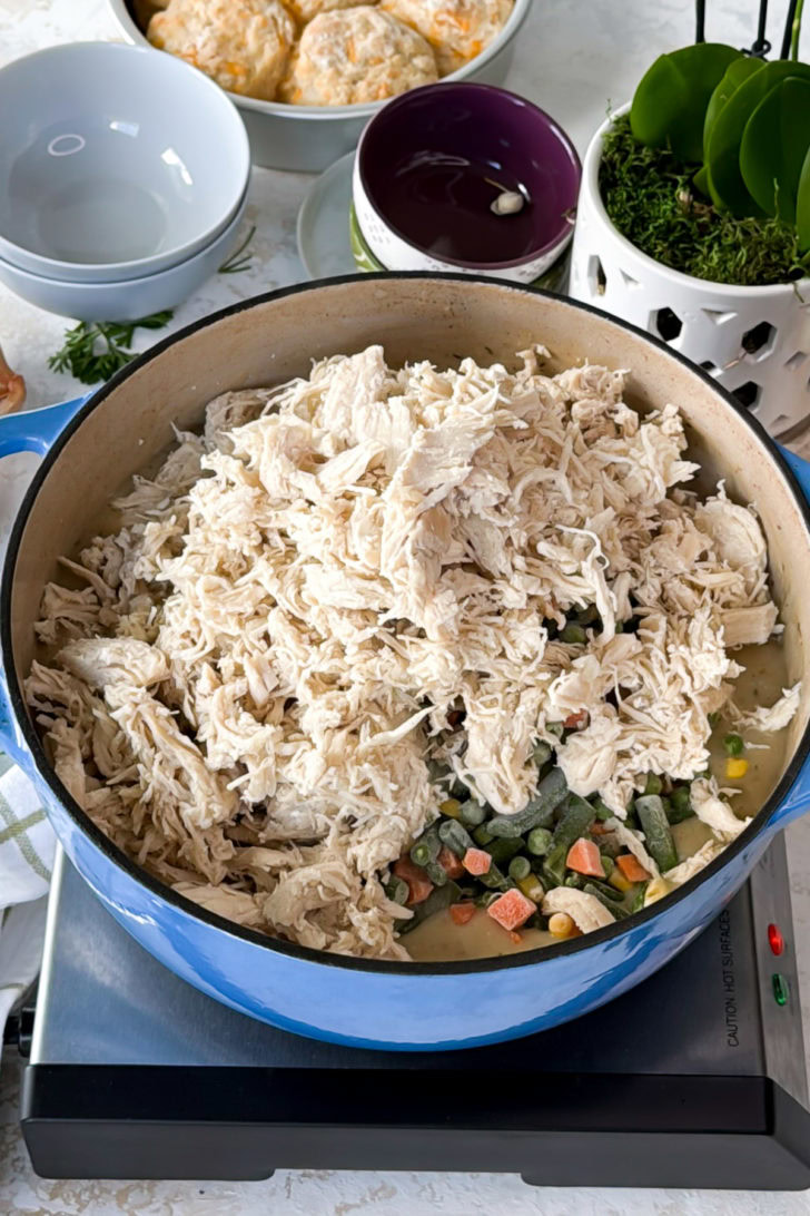 Frozen veggies and shredded chicken added to soup.