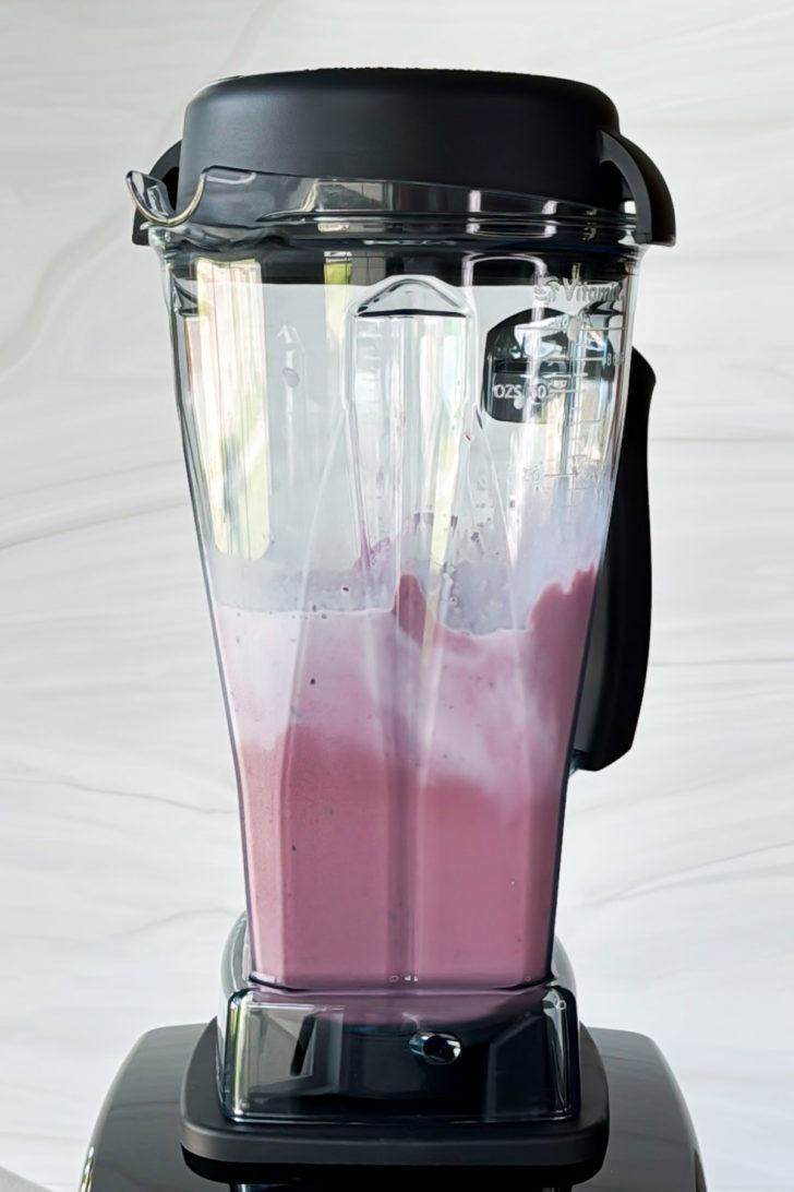 Blender with cherry milkshake inside.