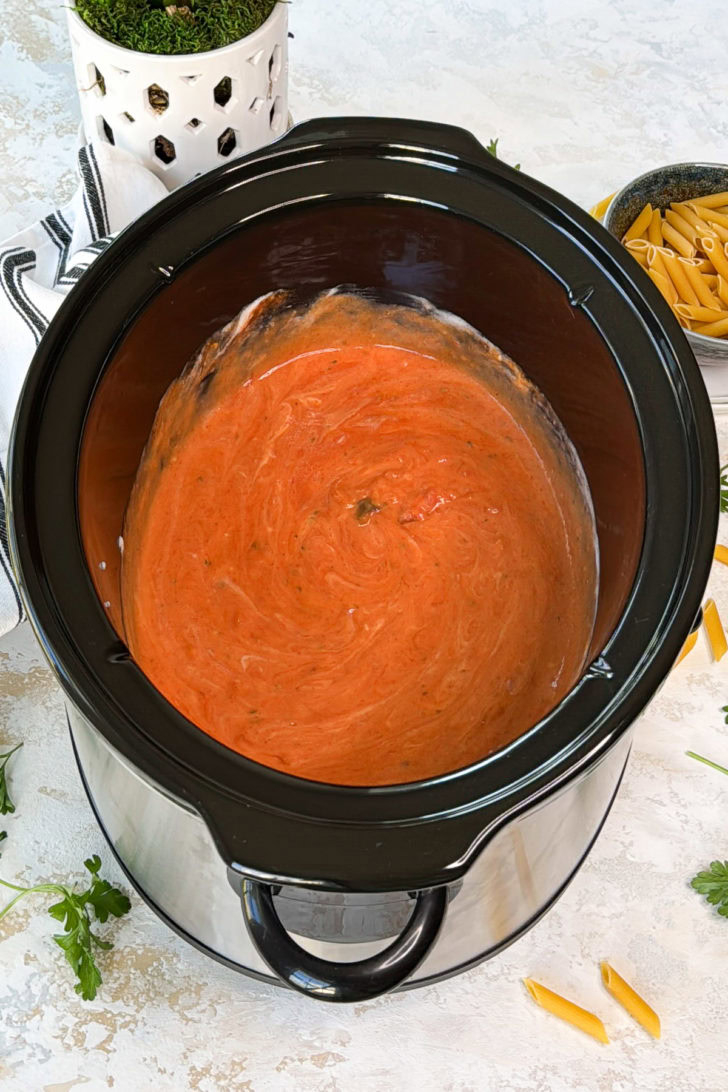 Marinara and alfredo sauce mixed in a slow cooker.