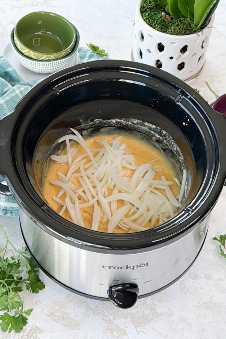 Sliced onions added on top of the gravy mixture.