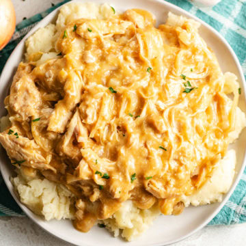 Crockpot chicken and gravy served over mashed potatoes.