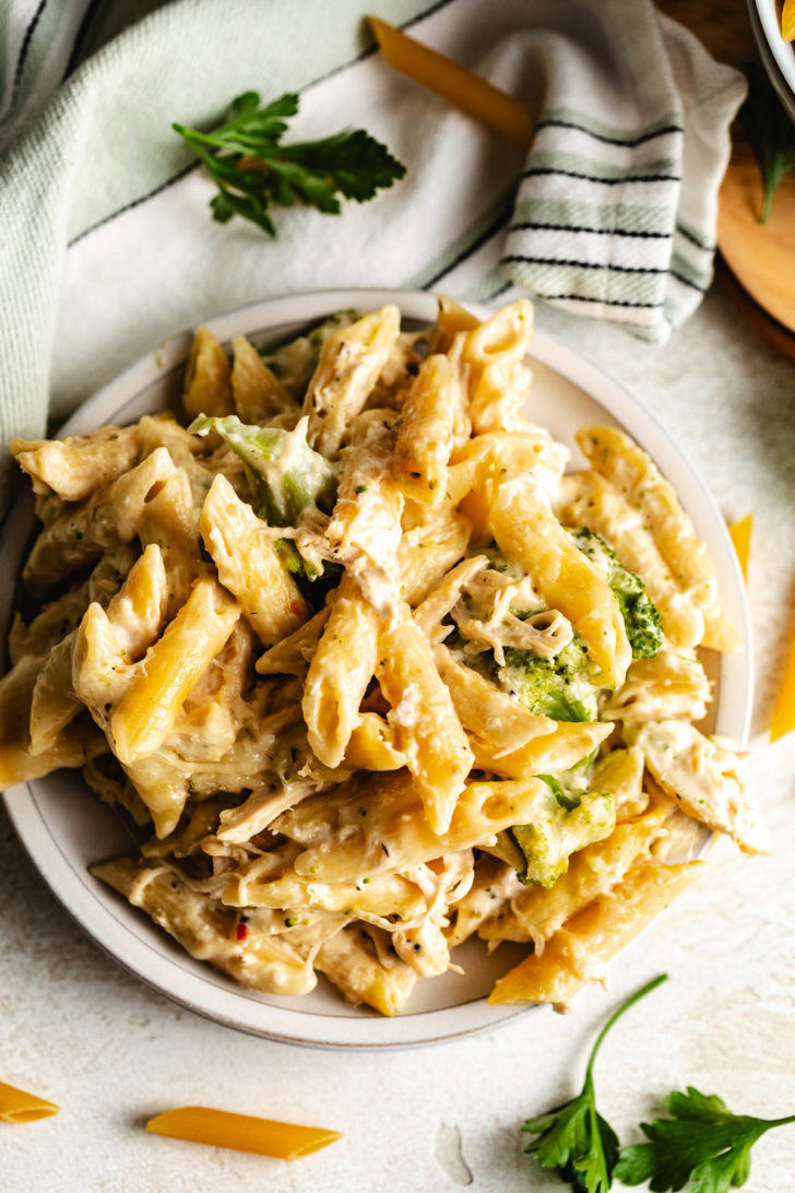 Plated chicken broccoli pasta with penne coated in a cream cheese sauce.