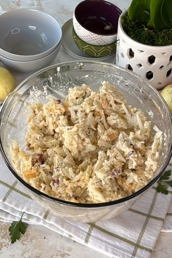 Mixed potato and cheese filling in a glass bowl.