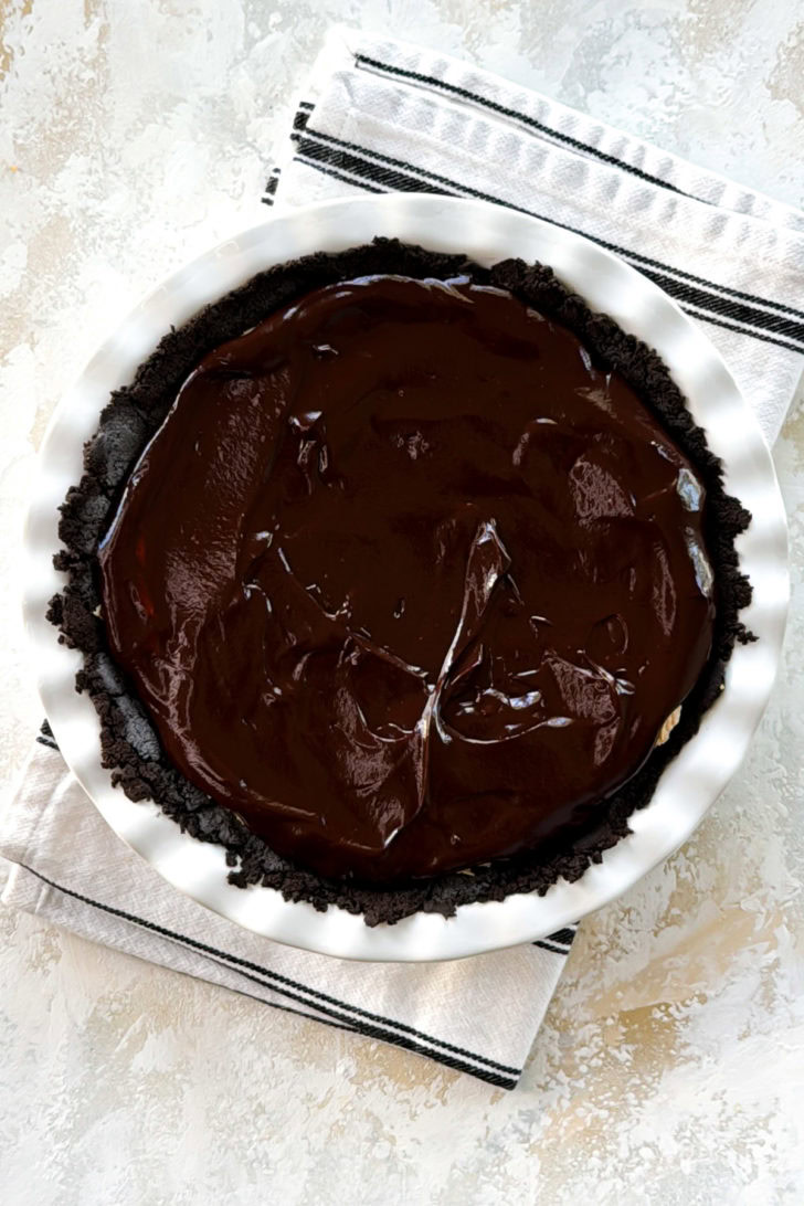 Chocolate ganache spread over a peanut butter pie.