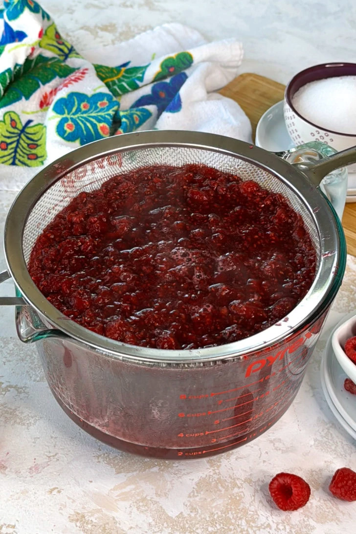 Raspberry mixture in a strainer.