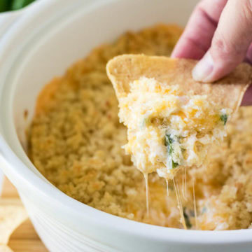 Baked jalapeño popper dip on a tortilla chip.